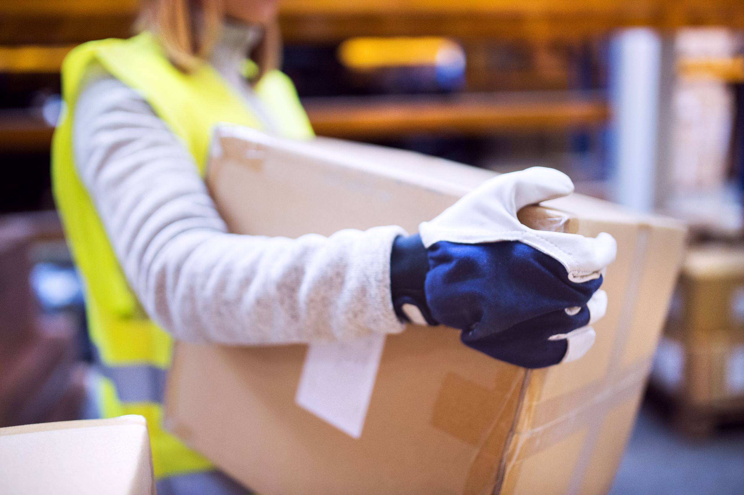 A mover wearing gloves and picking up boxes